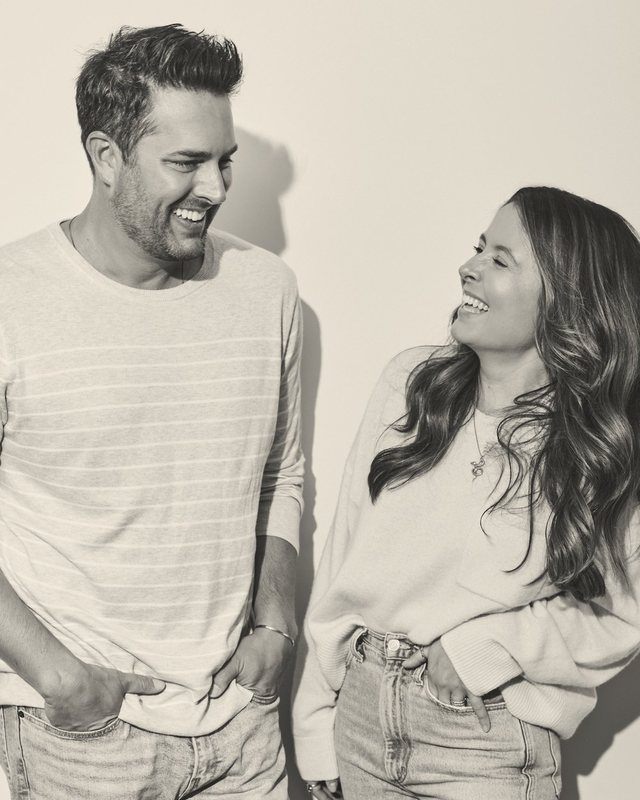 Two team members laughing together in a black-and-white portrait